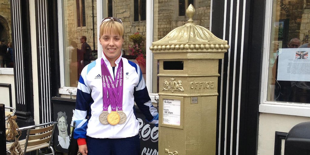 Local Paralympian Sophie Wells with her gold postbox in uphill Lincoln.