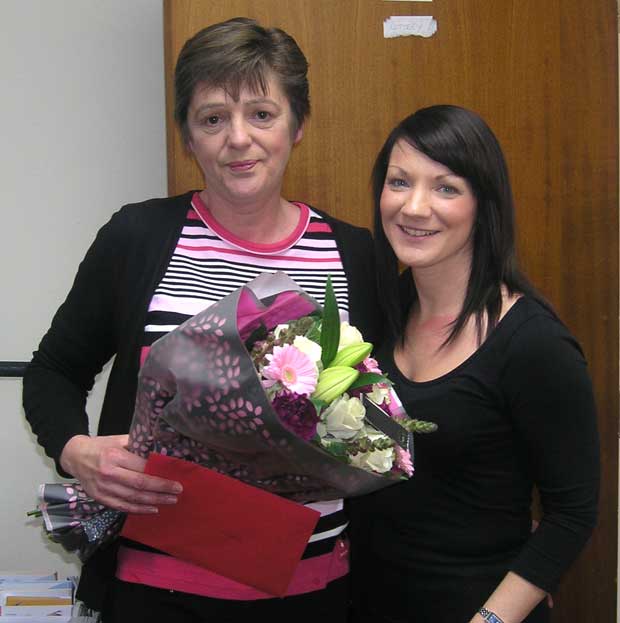  Marie Pattison receives a bunch of flowers and spa day gift voucher from Fundraising Manager Veronica Brien. Photo: St Barnabas