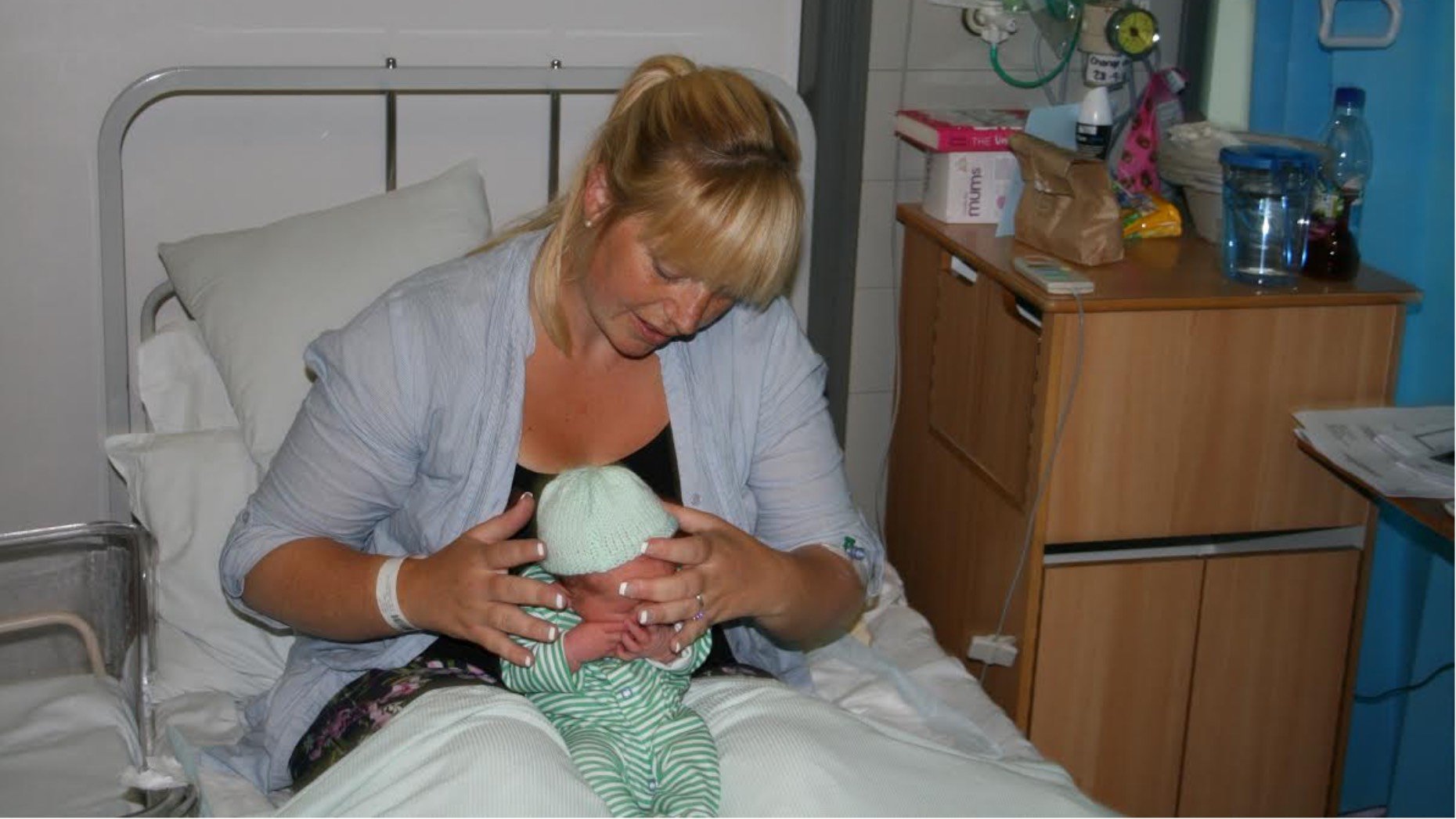 Mother Bonnie Henton puts one of the hats on baby Fergus Henton, aged 2 days.