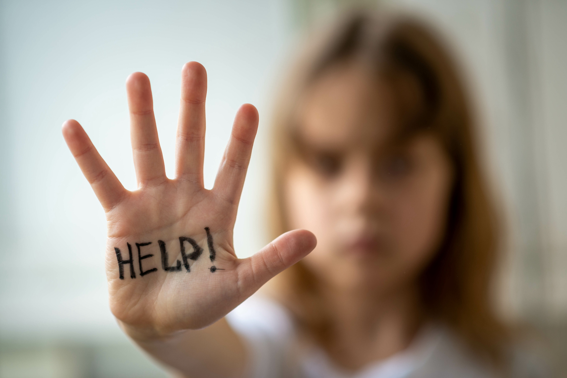 Little girl asks for help, help written on hand. Domestic and child abuse. Protecting the rights of the child.